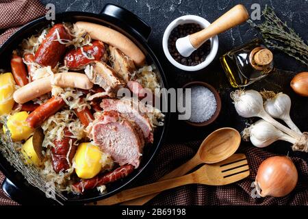 Regione francese dell'Alsazia piatto choucroute garnie di cavolo acido con pancetta affumicata, lombata di maiale, salsicce stufate in vino bianco con cipolla e aglio al buio Foto Stock