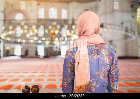 Una donna in una sciarpa che prega in una moschea, in Turchia Foto Stock