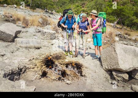 Gruppo di amici turisti che guardano gas naturale brucia nel parco nazionale Olympos, le luci della chimera, Turchia Foto Stock