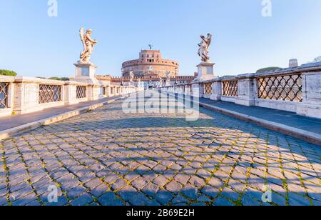 Strada stoppie vuota attraverso il ponte deserto Ponte Sant' Angelo che conduce a Castel Sant' Angelo / l'ex Mausoleo di Adriano a Roma Foto Stock