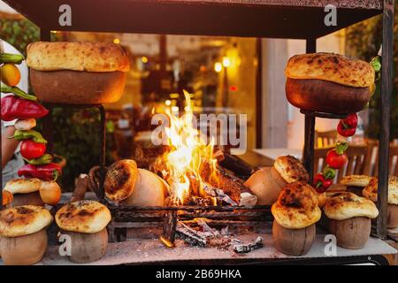 Tradizionale turco Testi Kebab cucinato in vaso di argilla sul fuoco aperto di notte nel ristorante, autentica cucina orientale Foto Stock