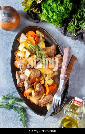 fegato fritto con patate e verdure su piastra metallica Foto Stock