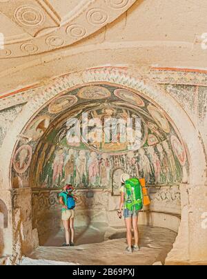 I viaggiatori attivi degli amici esplorano affreschi e dipinti dell'antica chiesa crociata in Cappadocia Foto Stock