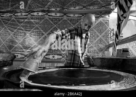 Alessandria, Egitto 6 febbraio 2019 il creatore e venditore di Konafa durante il mese santo del Ramadan che è un deserto arabo tradizionale Foto Stock