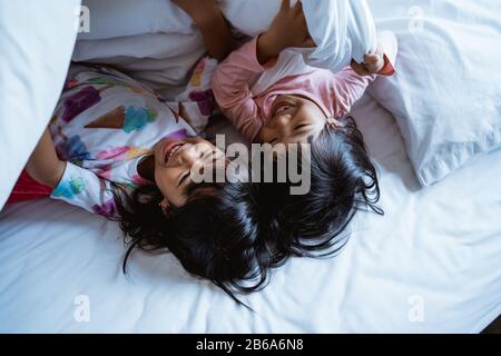 due ragazze piccole che si divertono e ridono a letto quando si svegliano Foto Stock