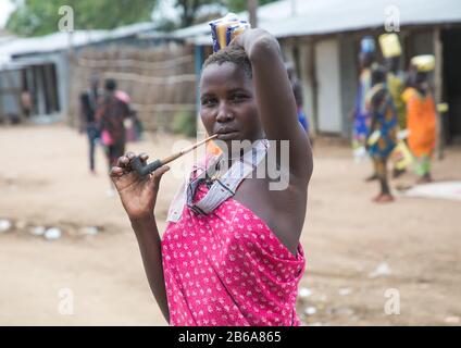 Toposa tribù donna fumare tubo in strada, Namorunyang Stato, Kapoeta, Sudan del sud Foto Stock