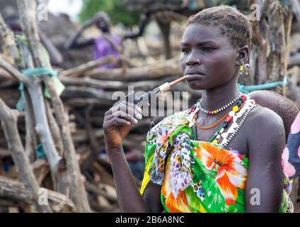 Toposa tribù donna fumare tubo in un villaggio, Namorunyang Stato, Kapoeta, Sudan del sud Foto Stock