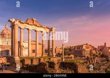 Tramonto sul Tempio di Saturno e foro romano antiche rovine, Roma, Italia Foto Stock