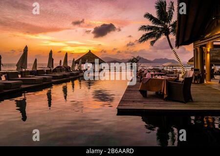 Piscina di lusso in resort tropicale, vacanze rilassanti nelle isole Seychelles. La Digue, tramonto a swimpool Foto Stock