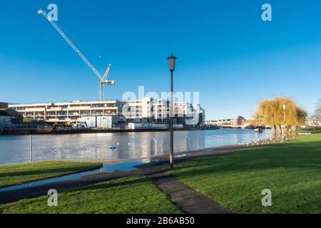 Il fiume Nene in alluvione nel centro di Peterborough, Cambridgeshire, nel gennaio 2020, con grandi gru e Fletton Quays lavori di costruzione in background Foto Stock