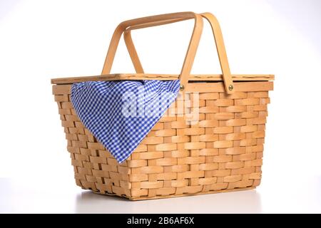 Cestino picnic in vimini su sfondo bianco con tovaglia blu di gingham Foto Stock