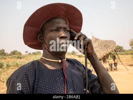 Mundari tribù uomo che chiama sul suo cellulare, Equatoria Centrale, Terekeka, Sudan del Sud Foto Stock