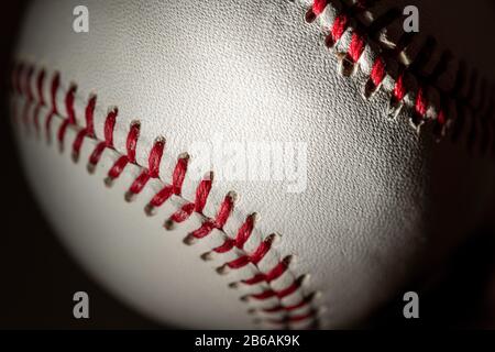 Un baseball bianco in pelle su sfondo nero Foto Stock