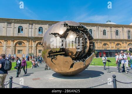 Città del Vaticano / Italia - 20 aprile 2019: Sfera All'Interno della sfera (sfera con sfera) globo d'oro con turisti sullo sfondo Foto Stock