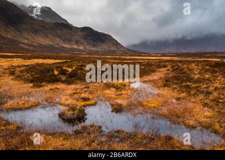 Paludi nella valle vicino Buachaille Etive Mor in una giornata di moody, Glencoe, Scozia Foto Stock