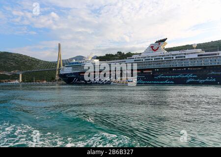 La nave da crociera TUI Cruises Mein Schiff 2 ormeggiata vicino al ponte sospeso con una vecchia nave a vela passato a Dubrovnik, Croazia Foto Stock