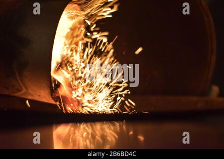 Scintille e fiamme che sparano dal barbecue starter in serata oscura Foto Stock