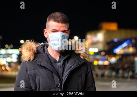 Uomo che indossa maschera medica per la protezione del coronavirus. Foto Stock