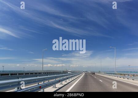 Le auto stanno guidando su un nuovo ponte che collega le rive dello stretto di Kerch tra Taman e Kerch. Ponte Crimea 19 maggio 2018 Foto Stock