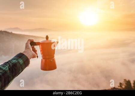 Macchina da caffè in alluminio geyser sullo sfondo di nebbia e mountians Foto Stock