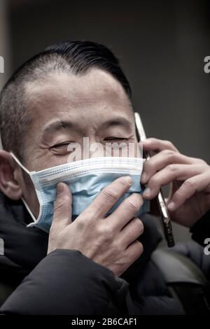 Uomo asiatico di mezza età che indossa una maschera medica Foto Stock