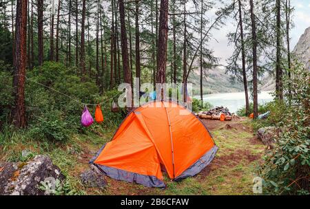 Camping Tent nella foresta di fronte al lago di montagna Foto Stock