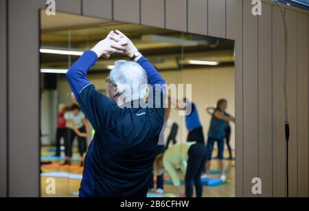 3 marzo 2020, Baden-Wuerttemberg, Stoccarda: I partecipanti fanno esercizi di stretching durante una lezione sportiva per persone oltre i 60 anni. Foto: Sebastian Gollnow/Dpa Foto Stock