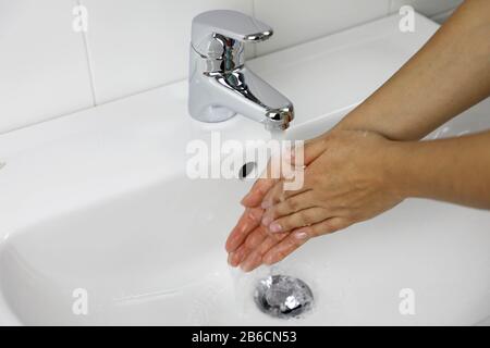 COVID-19 lavarsi le mani in bagno lavarsi a casa contro Il Nuovo coronavirus (2019-nCoV). Concetto di igiene e assistenza sanitaria. Foto Stock