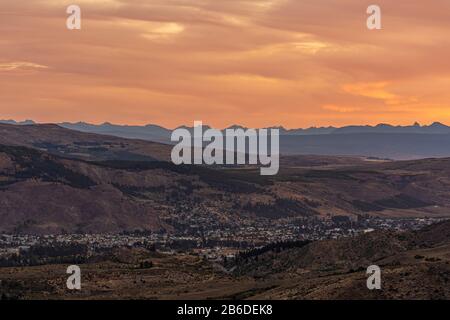 Vista del paesaggio urbano di Esquel contro le Ande durante il colorato tramonto in Patagonia, Argentina Foto Stock