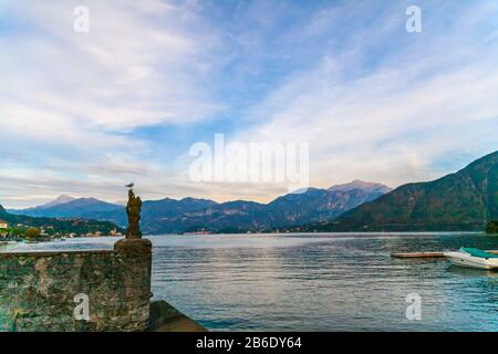 Un gabbiano su un molo sul lago di Como al tramonto, Italia Foto Stock