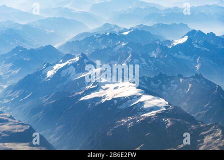 Paesaggio vista aerea delle Alpi blu montagne con nuvole sopra la Svizzera. Foto Stock