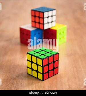 Diversi Rubik cubi intelligenza giocattoli risolti, in un tavolo di legno Foto Stock