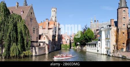 Tourboat in un canale, Bruges, Fiandre Occidentali, Belgio Foto Stock