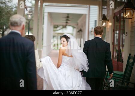 Ritratto di una giovane sposa adulta che cammina con lo sposo e la madre adulta matura. Foto Stock