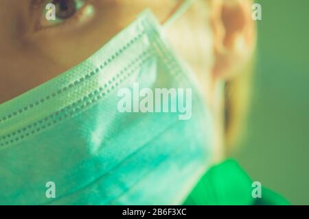 Parte di una faccia femminile in una maschera medica. Primo piano, concentrarsi sulla maschera Foto Stock