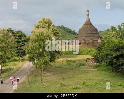 Tre donne e uomo sulla strada vicino al Tempio di Andaw-thein, Mrauk U, Stato di Rakhine, Myanmar Foto Stock