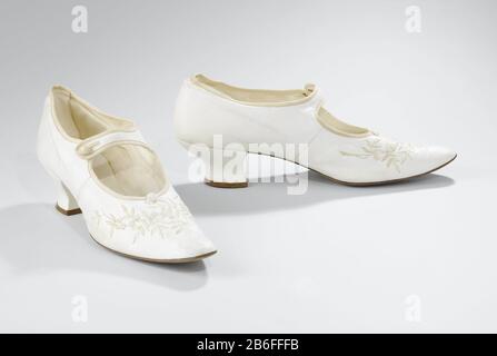Rechterbruidsschoen van wit glacé-leer, op het voorblad met geborduurde crème takjes en witkralen bloemen; afgeronde spitse neus, Pompadourhak met leer overtrokken, wreefbandje. Produttore : schoenmaker: AnoniemPlats fabbricante: Nederland Dating: In of voor 1909 kenmerken Fisico: Leer Materiale: Geheel: Glacéleer Techniek: Borduren dimensioni: Geheel: L 24 cm. × b 7,5 cm. × h 9 cm. Data: 1909 - 1909 Foto Stock