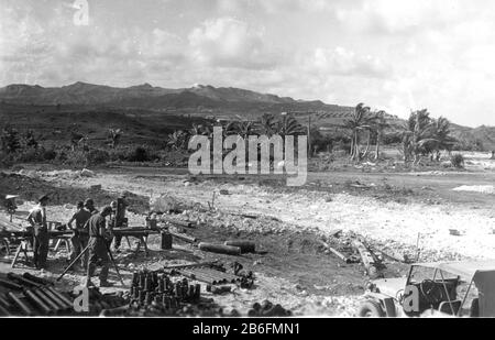 Seabees su Guam, n. 1 - caduta di 1944, taglio, preparazione tubi fognari da posare lungo la strada sterrata molto ruvida e rocciosa. Un serbatoio di propano è a terra, benzina può alla sua sinistra. Jeep in basso a destra. In lontananza si trova un campo di tende di fronte alle montagne. Questi Seabee stanno iniziando la costruzione di strade e edifici per gli edifici degli ufficiali CINCPAC. Per vedere le mie immagini d'epoca correlate, Cerca: Prestor vintage WW II Foto Stock