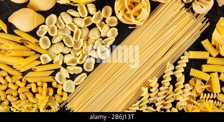 Panorama della pasta italiana, piatto di vari tipi di pasta, top shot su sfondo nero Foto Stock