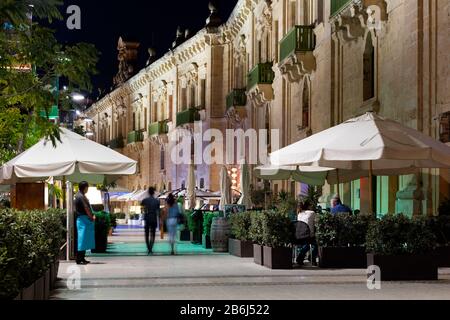 I giovani si divertono una serata fuori nei bar e ristoranti sul lungomare di la Valletta, Malta. Foto Stock