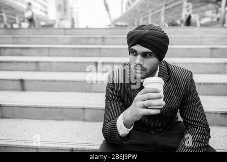 Giovane e bell'uomo d'affari sikh indiano presso la scala della città Foto Stock