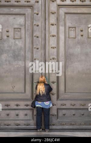 I turisti cercano di vedere l'interno del Pantheon, le cui famose porte sono state chiuse al pubblico come parte delle precauzioni Coronavirus a Roma, Italia Foto Stock