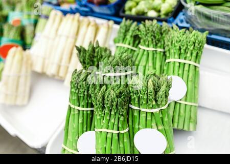 Asparagi verdi e bianchi al banco del mercato agricolo Foto Stock