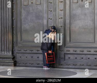 I turisti cercano di vedere l'interno del Pantheon, le cui famose porte sono state chiuse al pubblico come parte delle precauzioni Coronavirus a Roma, Italia Foto Stock