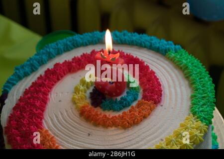 Compleanno - anniversario torta colorata con candela rossa accesa che mostra nr. 5 Foto Stock