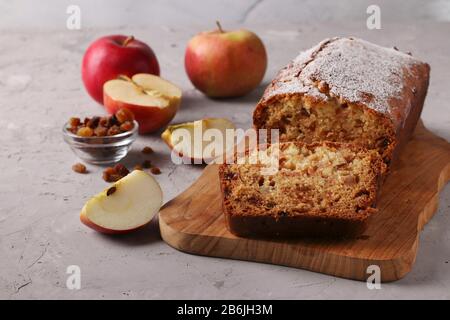 Muffin fatti in casa con mele e uva passa su una tavola di legno su uno sfondo grigio Foto Stock