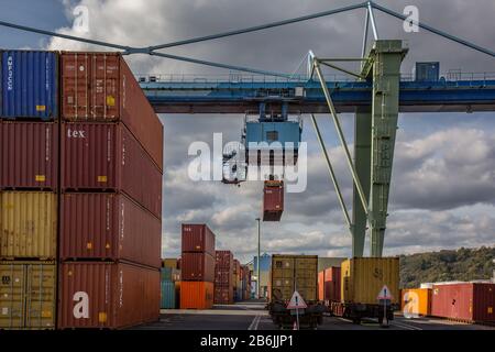 Andernach, Renania-Palatinato, Germania - 25 ottobre 2019: In un terminal container un container viene sollevato da un ponte di gru Foto Stock