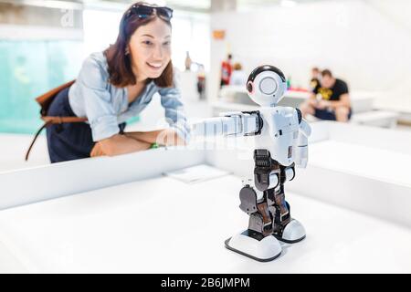 21 AGOSTO 2017, ULTRA MALL, UFA, RUSSIA: Una studentessa controlla il lavoro di un robot umanoide intelligente Foto Stock