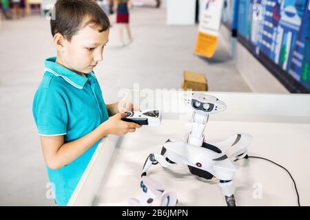 21 AGOSTO 2017, ULTRA MALL, UFA, RUSSIA: Un ragazzo costruisce e gioca con un robot in una mostra di tecnologie moderne Foto Stock