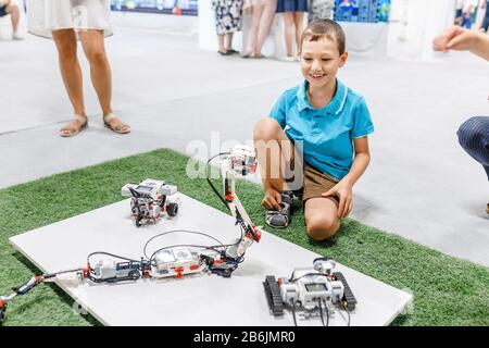 21 AGOSTO 2017, ULTRA MALL, UFA, RUSSIA: Un ragazzo costruisce e gioca con un robot in una mostra di tecnologie moderne Foto Stock